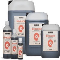 BioBizz Bio Bloom -nestemäinen luomulannoite pullo etiketillä ja runsaasti kukkivia kasveja.