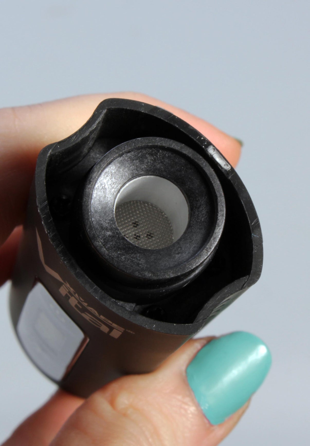 Musta XMAX Vital yrttivaporisaattori, näyttää laitteen kädessä tyylikkäästi muotoiltuna, OLED-näyttö näkyvissä.