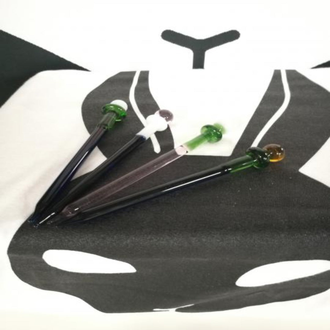 Kuva 10 cm pitkästä läpinäkyvästä lasisesta däppitikusta, joka on suunniteltu tarkkaan konosentraattien käsittelyyn. Pinnalla voi näkyä heijastuksia ja kirkkautta.