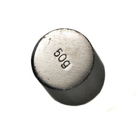 Kuva 50 gramman kiillotetusta, sylinterimäisestä kalibrointipainosta vaa'an tarkkuuden varmistamiseksi