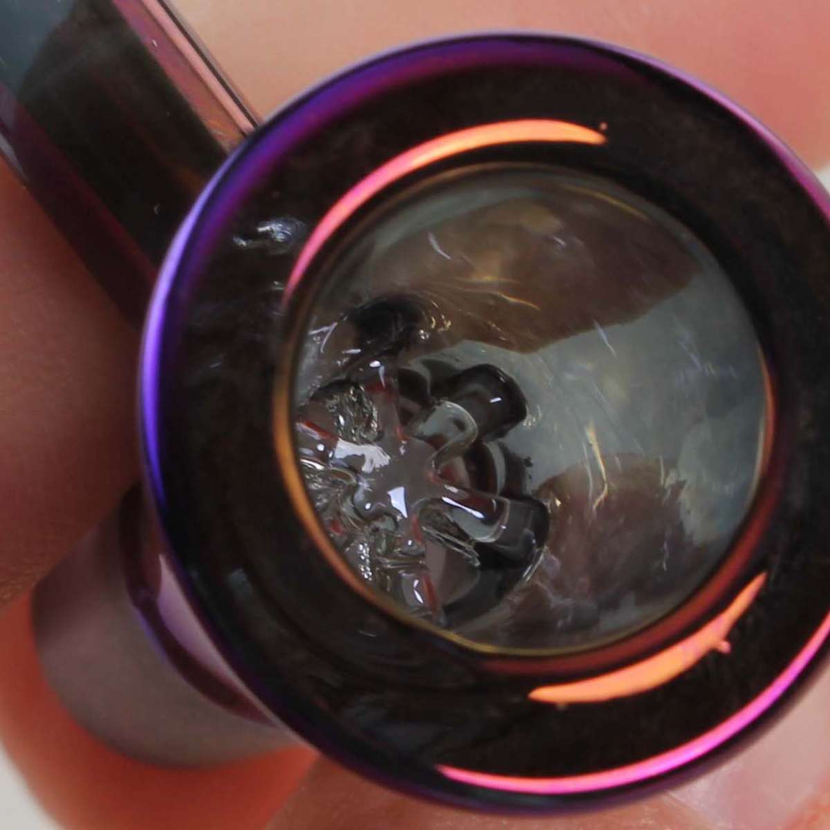 Lähikuva Pesäkuppi Metallic Kahvalla 14.5mm -lasipesästä, jossa näkyy violetti metallinhohtoinen pinta ja ergonomisesti muotoiltu, kirkas lasikahva.