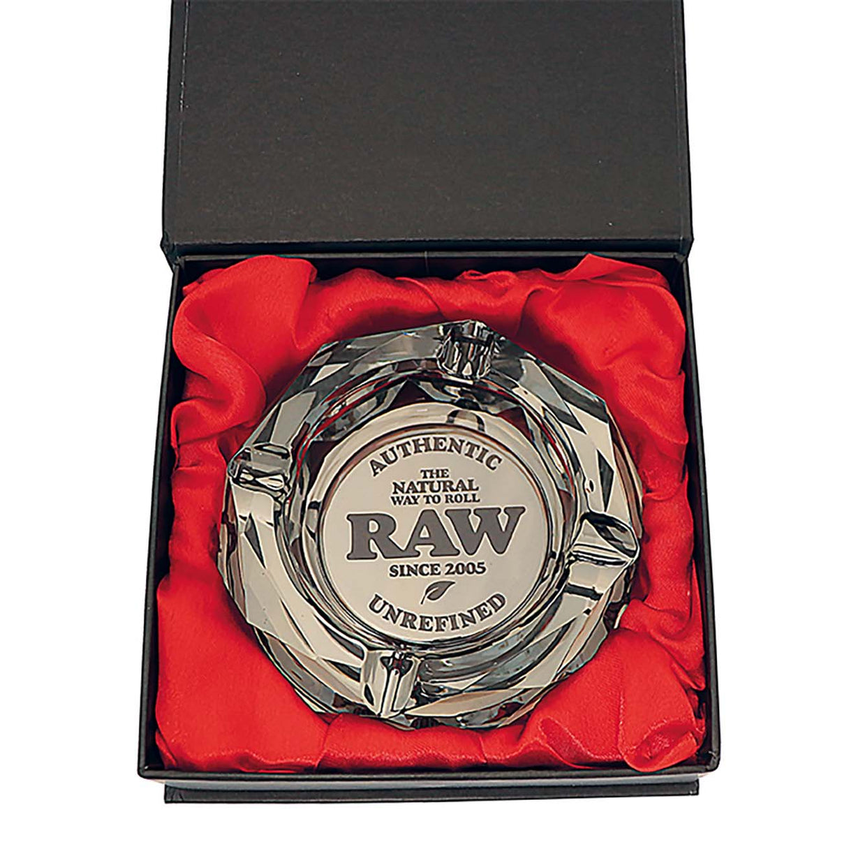 RAW Darkside Crystal -lasituhkakuppi pöydällä, valaistuna, tumma pohja ja kiiltävät leikkaukset heijastamassa valoa.