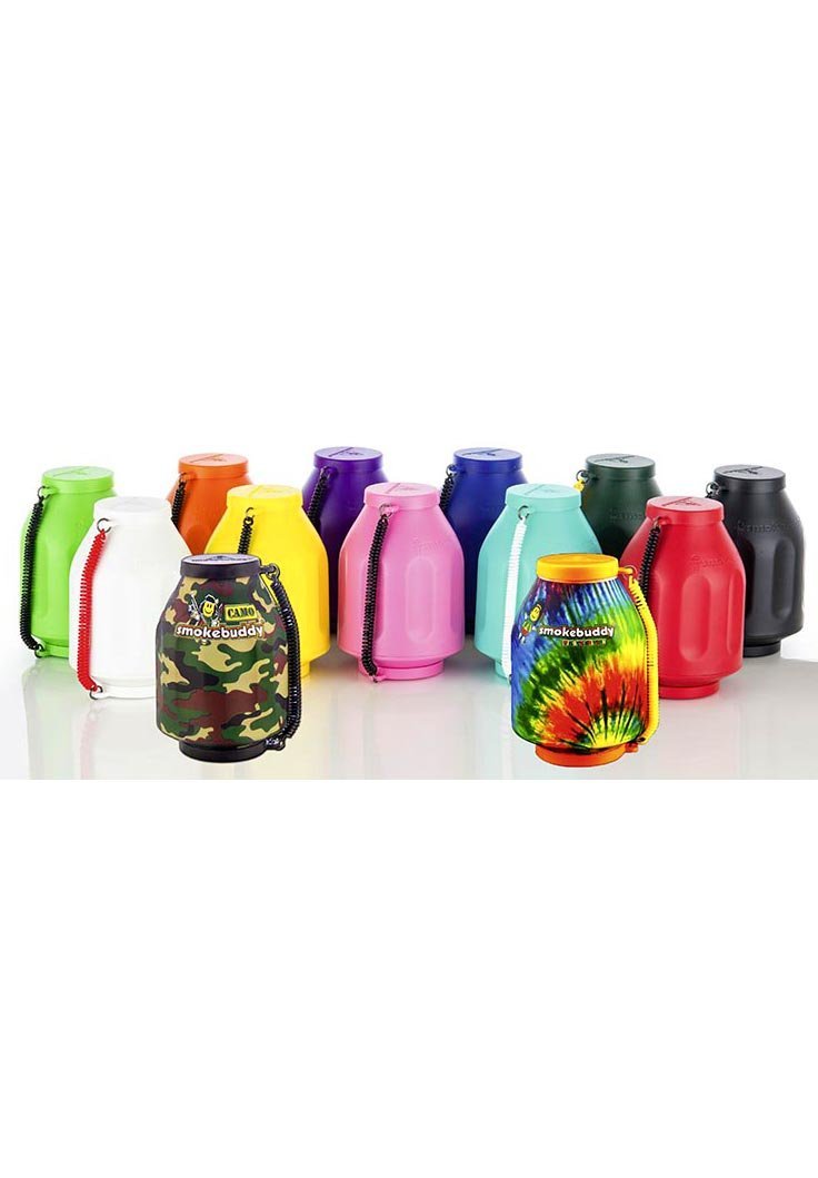 Musta Smokebuddy Original henkilökohtainen ilmansuodatin pöydällä, valkoista savua imeytymässä laitteeseen, taustalla heikosti näkyvä kasvi.